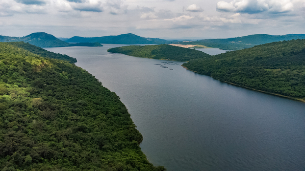 Aerial view of Lake Volta surrounded by lush green hills and dense forest under a cloudy sky in Akosombo Eastern Region Ghana. Aerial view of Lake Volta surrounded by lush green hills and dense forest under a cloudy sky in Akosombo Eastern Region Ghana.