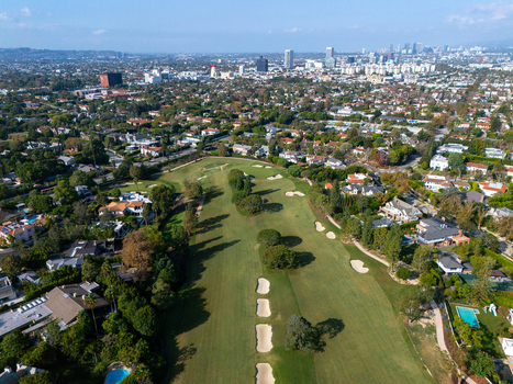 Aerial view of Wilshire Country Club with green fairways sand bunkers and surrounding residential neighborhoods under a clear sky Los Angeles California United States. Aerial view of Wilshire Country Club with green fairways sand bunkers and surrounding residential neighborhoods under a clear sky Los Angeles California United States.