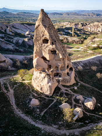 Aerial view of Uchisar Castle a historic rock cut fortress carved into volcanic tuff surrounded by the unique landscape of Cappadocia in Uchisar Nevsehir Turkiye. Aerial view of Uchisar Castle a historic rock cut fortress carved into volcanic tuff surrounded by the unique landscape of Cappadocia in Uchisar Nevsehir Turkiye.
