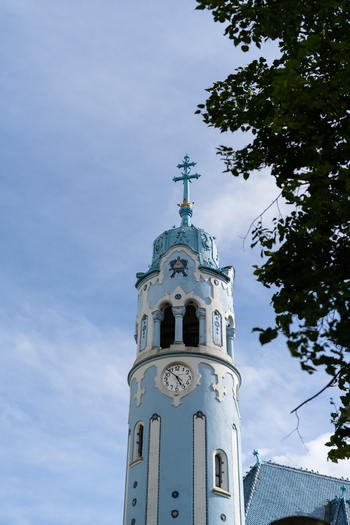 View of the ornate Art Nouveau tower of the Blue Church featuring a clock and a cross against a clear sky in Bratislava Bratislava Region Slovakia. View of the ornate Art Nouveau tower of the Blue Church featuring a clock and a cross against a clear sky in Bratislava Bratislava Region Slovakia.