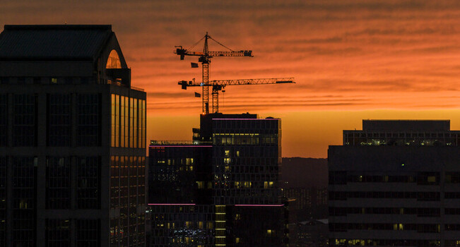 Aerial view of Downtown Nashville skyline at sunset with a construction crane silhouetted against a vibrant orange sky Nashville TN United States.