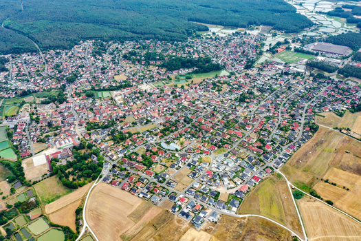 Aerial view of the town of Rottenbach featuring residential houses with red roofs lush green forests and agricultural fields in Rottenbach Bavaria Germany. Aerial view of the town of Rottenbach featuring residential houses with red roofs lush green forests and agricultural fields in Rottenbach Bavaria Germany.