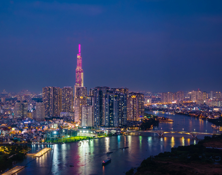 Aerial view of Landmark 81 skyscraper illuminated at night above the city skyline and river in Ho Chi Minh City Vietnam. Aerial view of Landmark 81 skyscraper illuminated at night above the city skyline and river in Ho Chi Minh City Vietnam.
