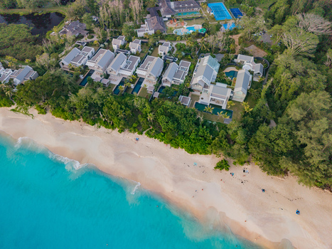 Aerial view of turquoise waters meeting the sandy shore fringed by lush green trees and modern white buildings Quatre Bornes Mahe Island Seychelles. Aerial view of turquoise waters meeting the sandy shore fringed by lush green trees and modern white buildings Quatre Bornes Mahe Island Seychelles.