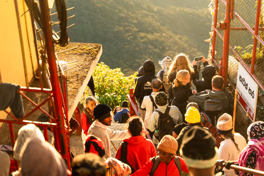 Ratnapura Sri Lanka 23 February 2026 View of pilgrims and tourists climbing the stairs of Adam s Peak at sunrise with lush green mountains in the background.
