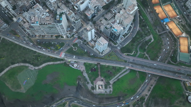 Aerial view of Love Park featuring lush green spaces winding paths and the surrounding urban skyline with high rise buildings and coastal roads in Miraflores Provincia de Lima Peru. Aerial view of Love Park featuring lush green spaces winding paths and the surrounding urban skyline with high rise buildings and coastal roads in Miraflores Provincia de Lima Peru.