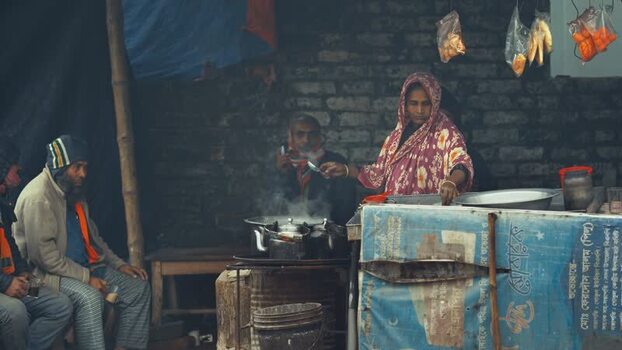 View of a woman preparing tea at a street stall Bangladesh. View of a woman preparing tea at a street stall Bangladesh.