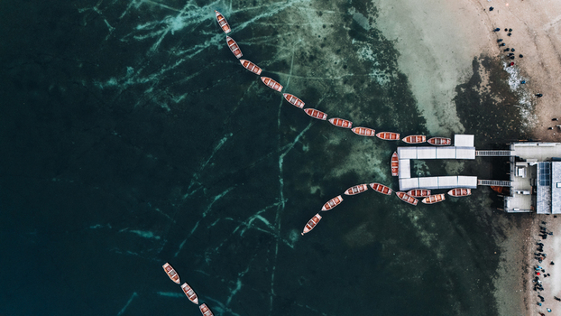 Aerial view of wooden rowing boats lined up on the emerald green water of Lake Braies near the wooden pier Braies Trentino Alto Adige Italy. Aerial view of wooden rowing boats lined up on the emerald green water of Lake Braies near the wooden pier Braies Trentino Alto Adige Italy.