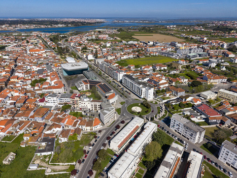 Aerial view of the urban landscape featuring a central roundabout diverse architecture and distant river Ilhavo Aveiro Portugal. Aerial view of the urban landscape featuring a central roundabout diverse architecture and distant river Ilhavo Aveiro Portugal.