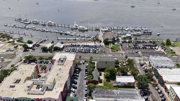 Aerial view of the bustling marina with white boats on dark waters next to buildings and busy streets Fernandina Beach Florida United States. Aerial view of the bustling marina with white boats on dark waters next to buildings and busy streets Fernandina Beach Florida United States.