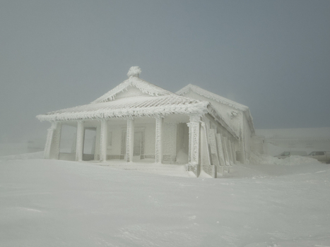 View of a building encased in thick ice stands starkly against the desolate snow covered landscape a testament to winter s harsh grip Covilh&atilde; Distrito da Guarda Portugal.