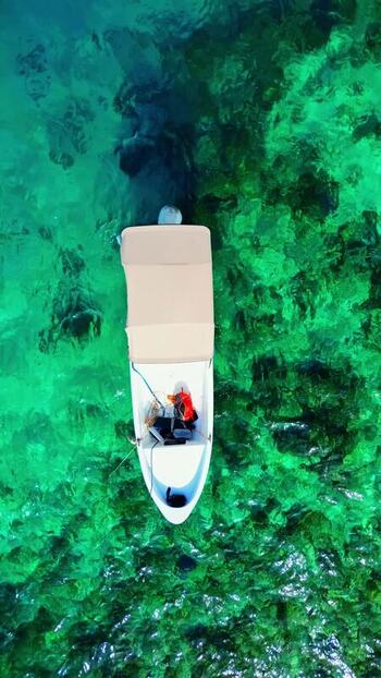 Aerial view of a small boat on crystal clear turquoise water Honduras. Aerial view of a small boat on crystal clear turquoise water Honduras.
