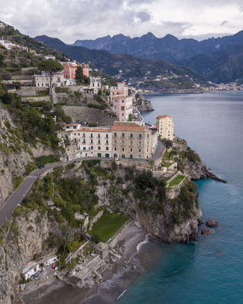 Aerial view of Atrani town and buildings perched along the Amalfi Coast where the rugged cliffs meet the turquoise sea Atrani Italy. Aerial view of Atrani town and buildings perched along the Amalfi Coast where the rugged cliffs meet the turquoise sea Atrani Italy.