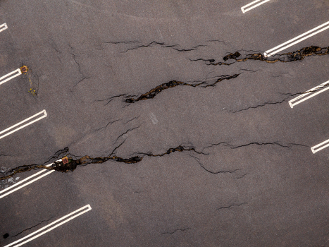 Aerial view of deep fissures and cracks in the asphalt surface of a parking lot in Iceland. Aerial view of deep fissures and cracks in the asphalt surface of a parking lot in Iceland.