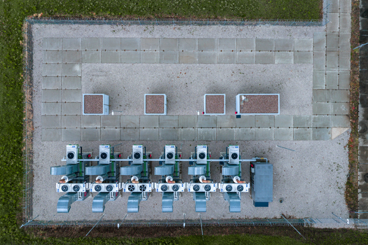 Aerial view of a technical industrial installation featuring a row of compressor units on a gravel surface with concrete slabs in Nasedlovice South Moravian Region Czechia.