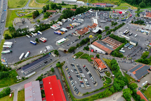 Geiselwind Germany 20 June 2025 Aerial view of the Heroes Festival Geiselwind area with crowded parking lots trucks and people queuing near the event grounds.
