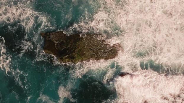 Aerial view of waves crashing against a rock United States.
