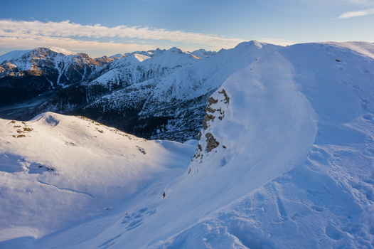 View of Ornak peak in the Western Tatras featuring snow covered mountain ridges under a clear blue sky in Tatra County Lesser Poland Voivode Poland. View of Ornak peak in the Western Tatras featuring snow covered mountain ridges under a clear blue sky in Tatra County Lesser Poland Voivode Poland.