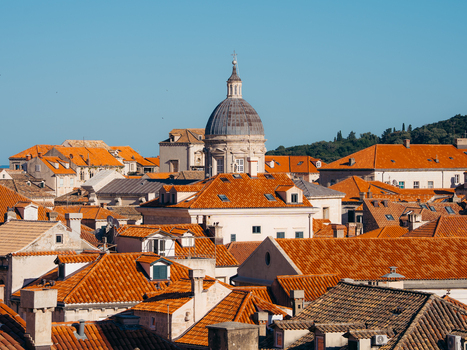 View of the iconic red tiled rooftops and the majestic dome of the cathedral under a clear blue sky in Dubrovnik Dubrovnik Neretva County Croatia. View of the iconic red tiled rooftops and the majestic dome of the cathedral under a clear blue sky in Dubrovnik Dubrovnik Neretva County Croatia.