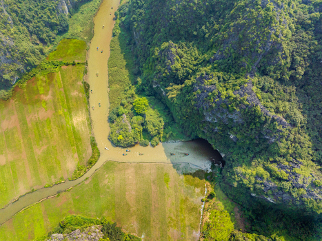 Aerial view of a river winding through lush karst mountains and green agricultural fields in Vietnam. Aerial view of a river winding through lush karst mountains and green agricultural fields in Vietnam.