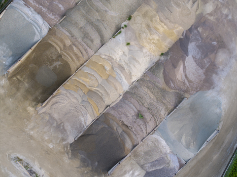 Aerial view of gravel and sand piles in different colors and textures stored in a quarry in Poland. Aerial view of gravel and sand piles in different colors and textures stored in a quarry in Poland.