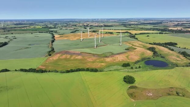 Aerial view of wind turbines and green fields in the countryside Germany.