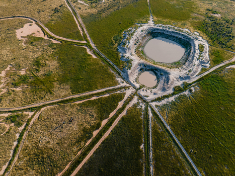 Aerial view of two circular ponds surrounded by dirt tracks in a flat landscape in Hay New South Wales Australia.