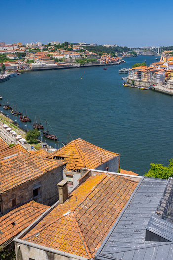 Aerial view of terracotta rooftops cascading towards the inky waters of the Douro River with Ribeira s colorful buildings lining the banks Porto Porto District Portugal. Aerial view of terracotta rooftops cascading towards the inky waters of the Douro River with Ribeira s colorful buildings lining the banks Porto Porto District Portugal.