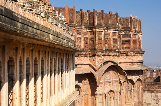 View of the intricate sandstone carvings and architectural details of Mehrangarh Fort under a clear blue sky in Jodhpur Rajasthan India. View of the intricate sandstone carvings and architectural details of Mehrangarh Fort under a clear blue sky in Jodhpur Rajasthan India.