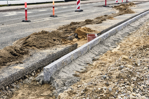 Viborg Denmark 07 August 2026 View of roadworks featuring the installation of new granite stone kerbs along a street with piles of sand and traffic cones. Viborg Denmark 07 August 2026 View of roadworks featuring the installation of new granite stone kerbs along a street with piles of sand and traffic cones.