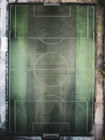 Aerial view of a soccer field with green artificial turf and white boundary lines in Lisbon Portugal.