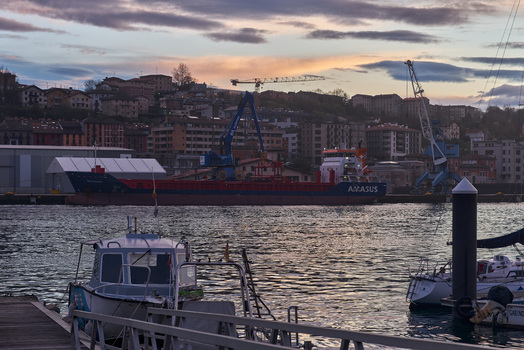 Pasai Donibane Spain 09 March 2026 View of Puerto Pasajes with a large cargo ship docked at the industrial harbor under a colorful sunset sky. Pasai Donibane Spain 09 March 2026 View of Puerto Pasajes with a large cargo ship docked at the industrial harbor under a colorful sunset sky.