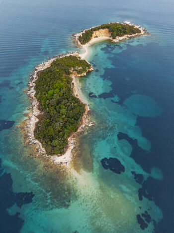 Aerial view of the Ksamil Islands surrounded by turquoise waters lush green vegetation and rocky shorelines in Ksamil Vlore County Albania. Aerial view of the Ksamil Islands surrounded by turquoise waters lush green vegetation and rocky shorelines in Ksamil Vlore County Albania.