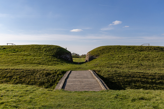 View of the historic Viking Fortress Trelleborg with its iconic earthen ramparts and wooden bridge under a clear blue sky in Slagelse Sjaeland Denmark. View of the historic Viking Fortress Trelleborg with its iconic earthen ramparts and wooden bridge under a clear blue sky in Slagelse Sjaeland Denmark.