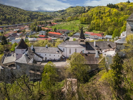 Aerial view of Orava Castle with its historic stone walls courtyard and church tower surrounded by lush green hills and a small town in Dolny Kubin Zilinsky kraj Slovakia. Aerial view of Orava Castle with its historic stone walls courtyard and church tower surrounded by lush green hills and a small town in Dolny Kubin Zilinsky kraj Slovakia.