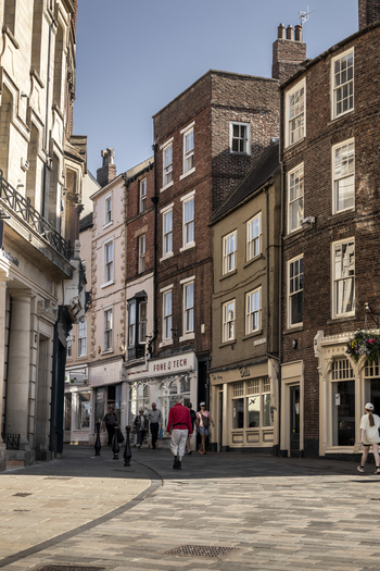 Durham United Kingdom 13 July 2026 View of historic brick buildings and storefronts along a narrow street with pedestrians walking on a sunny day. Durham United Kingdom 13 July 2026 View of historic brick buildings and storefronts along a narrow street with pedestrians walking on a sunny day.