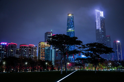 Guangzhou China 24 February 2024 View of the illuminated Guangzhou skyline at night featuring the International Finance Center modern skyscrapers and trees in the foreground. Guangzhou China 24 February 2024 View of the illuminated Guangzhou skyline at night featuring the International Finance Center modern skyscrapers and trees in the foreground.