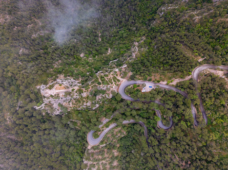 Aerial view of Sanctuary of Sant Salvador on a rocky peak overlooking a winding mountain road through dense green forest Felanitx Illes Balears Spain. Aerial view of Sanctuary of Sant Salvador on a rocky peak overlooking a winding mountain road through dense green forest Felanitx Illes Balears Spain.