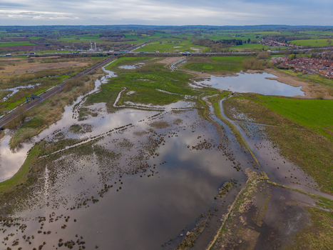 Aerial view of Doxey Marshes featuring wetlands winding waterways and surrounding green fields with a railway line and distant residential area in Stafford England United Kingdom. Aerial view of Doxey Marshes featuring wetlands winding waterways and surrounding green fields with a railway line and distant residential area in Stafford England United Kingdom.