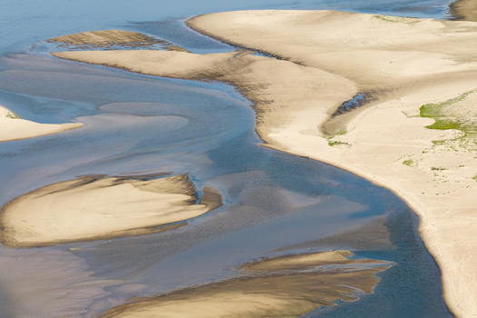 Aerial view of a riverbed with low water levels and exposed sandbanks in Poland.