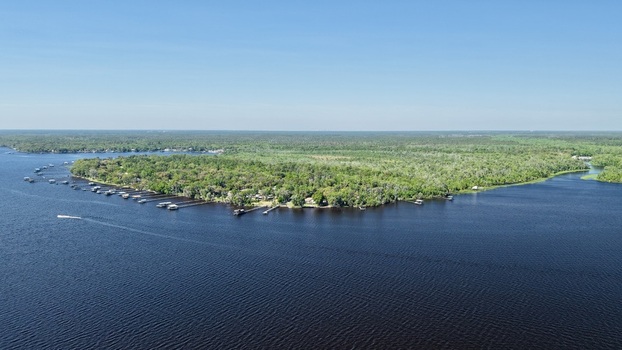 Aerial view of dark waters reflecting the sky bordered by lush green trees and docks along Palmo Fish Camp Road St. Augustine Florida United States. Aerial view of dark waters reflecting the sky bordered by lush green trees and docks along Palmo Fish Camp Road St. Augustine Florida United States.