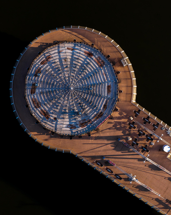 Aerial view of the circular pier structure on the Vistula river featuring a radial roof design and wooden deck with seating in Plock Masovian Voivodeship Poland. Aerial view of the circular pier structure on the Vistula river featuring a radial roof design and wooden deck with seating in Plock Masovian Voivodeship Poland.