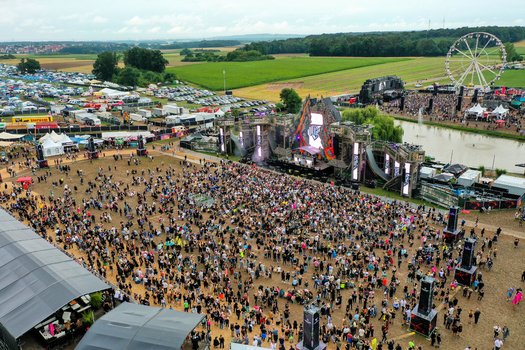 Herzogenaurach Germany 26 July 2025 Aerial view of the Open Beatz Festival with a large crowd main stage and ferris wheel surrounded by green fields.
