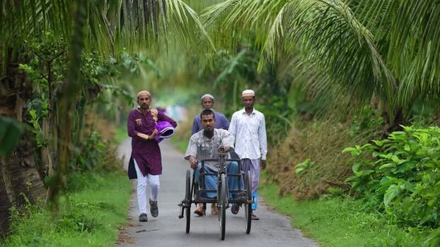 View of men walking on a rural road with a cycle van Bangladesh. View of men walking on a rural road with a cycle van Bangladesh.
