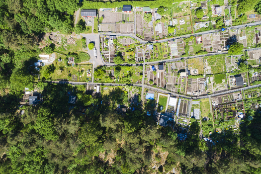 Aerial view of Rannebergen allotment gardens with small garden plots pathways and small structures surrounded by dense forest in Gothenburg Vastra Gotaland County Sweden. Aerial view of Rannebergen allotment gardens with small garden plots pathways and small structures surrounded by dense forest in Gothenburg Vastra Gotaland County Sweden.