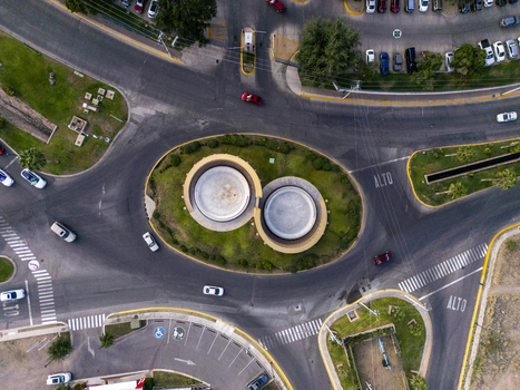 Aerial view of a circular roundabout featuring a unique double circular structure surrounded by green landscaping roads and parked cars in Chihuahua Chihuahua Mexico. Aerial view of a circular roundabout featuring a unique double circular structure surrounded by green landscaping roads and parked cars in Chihuahua Chihuahua Mexico.