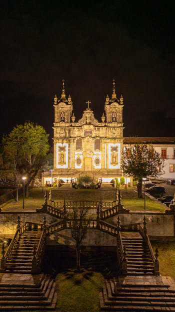 Aerial view of the illuminated Church of Santa Marinha da Costa and its grand stone staircase at night in Costa Guimaraes Portugal.