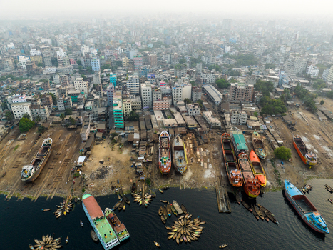 Aerial view of Sadarghat river port with numerous boats and ships docked along the Buriganga River surrounded by dense urban buildings in Dhaka Dhaka Division Bangladesh. Aerial view of Sadarghat river port with numerous boats and ships docked along the Buriganga River surrounded by dense urban buildings in Dhaka Dhaka Division Bangladesh.