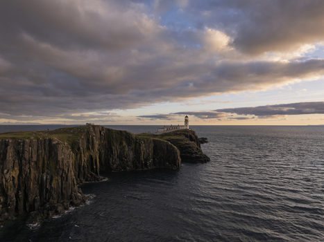Aerial view of Neist Point Lighthouse perched on dramatic sea cliffs at sunset with the Atlantic Ocean in the background Scotland United Kingdom. Aerial view of Neist Point Lighthouse perched on dramatic sea cliffs at sunset with the Atlantic Ocean in the background Scotland United Kingdom.