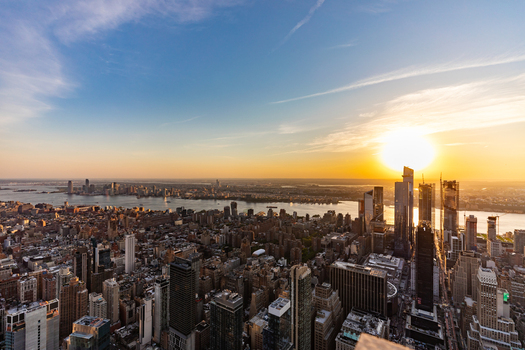 New York United States 09 August 2021 Aerial view of the New York City skyline at sunset featuring skyscrapers the Hudson River and golden light reflecting on the buildings.